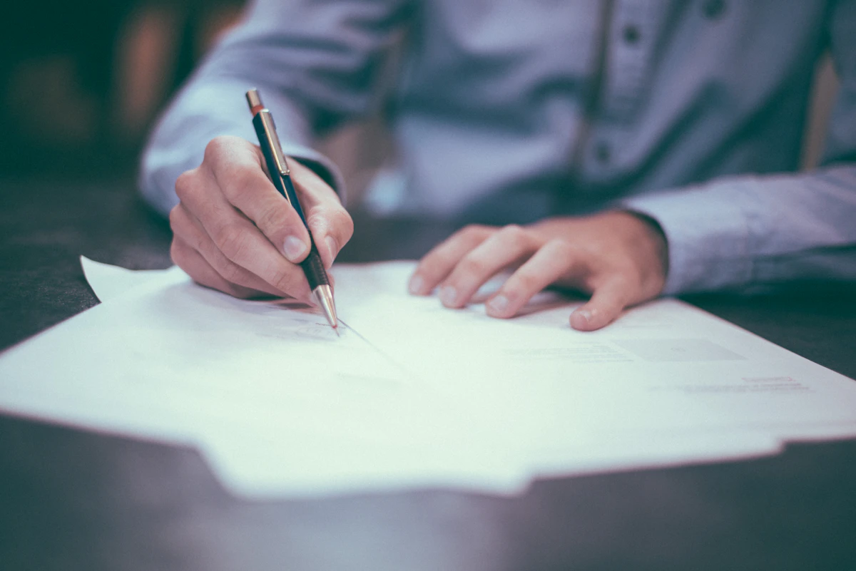 Solicitor signing a legal document at a desk